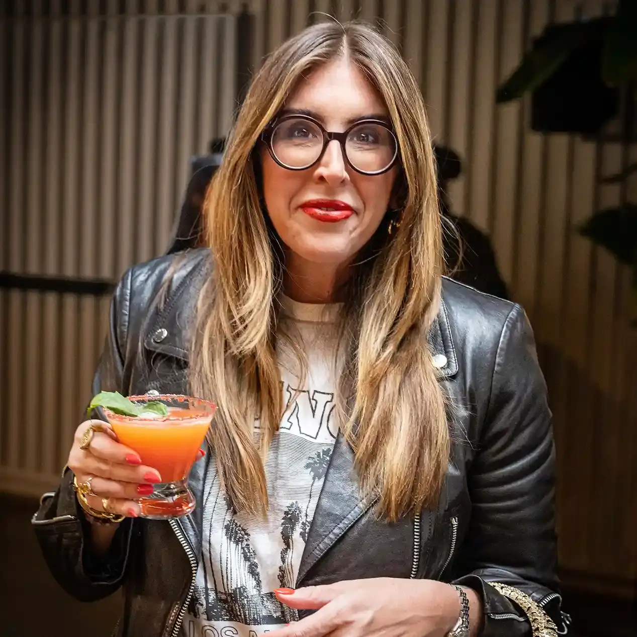 A fashionably dressed female guest with a Tipsy Tiger drink
