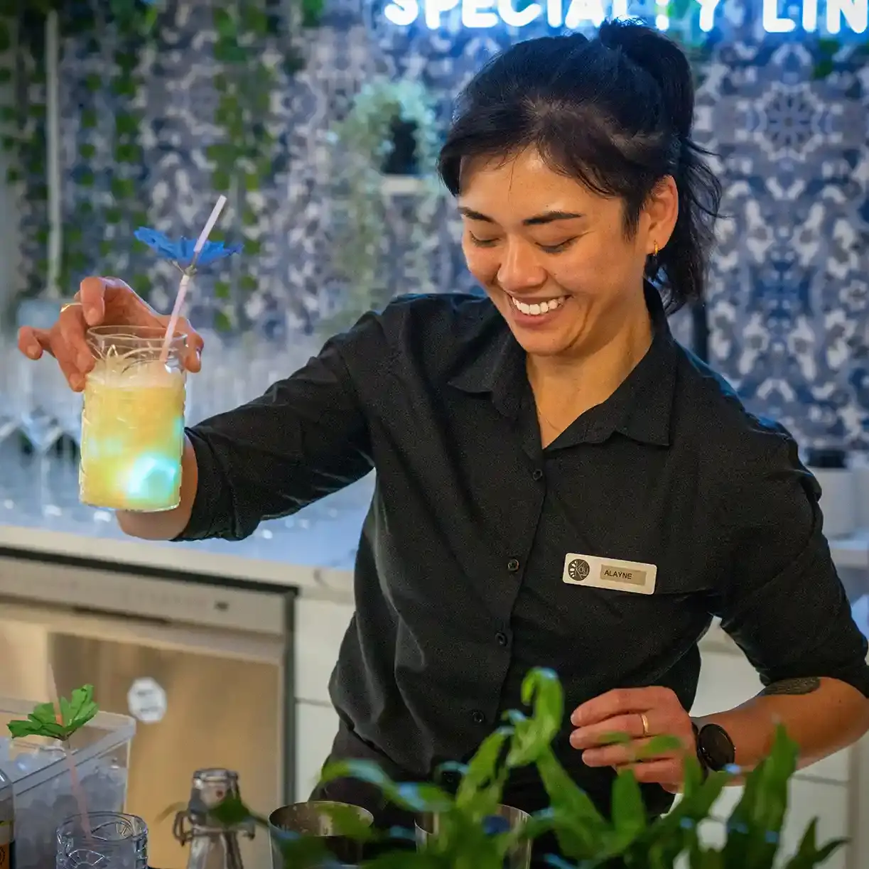 A smiling female Tipsy Tiger bartender serving a drink